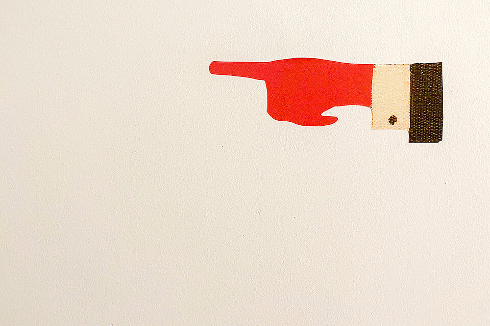 Hinweisgrafik – VHS Eching Programm Illustration: rote Hand mit ausgestrecktem Zeigefinger nach rechts. Wird im Programmheft und auf der Website der VHS Eching als Gestaltungselement verwendet.